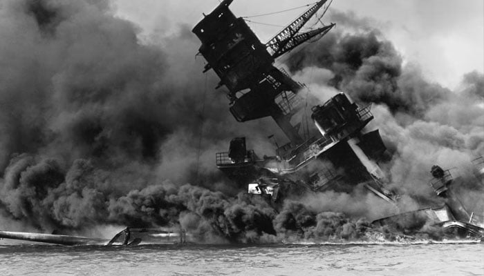 The forward superstructure of the sunken battleship USS Arizona burns after the attack. US Navy/US Naval History and Heritage Command.—Reuters