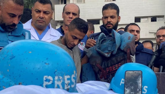 Colleagues of Palestinian journalists Mohammed Soboh and Saeed al-Taweel, who were killed when an Israeli missile hit a building while they were outside reporting, stand next to their bodies at a hospital in Gaza City on Oct. 10.—Reuters