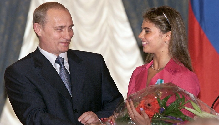 Russian President Vladimir Putin gives flowers to rhythmic gymnast and his secret lover Alina Kabaeva during an awards ceremony in Moscow in June 2001. —AFP