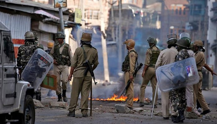 Indian policemen stand next to a burning handcart set on fire by demonstrators during a protest in Srinagar. — Reuters/File