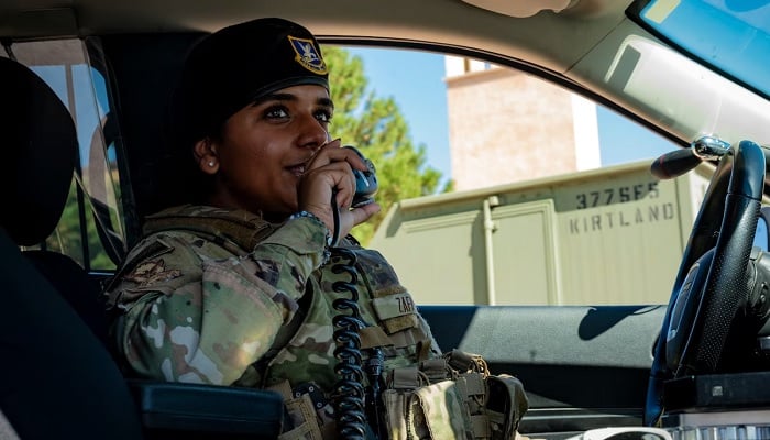Airman 1st Class Hamna Zafar, 377th Security Forces Squadron Airman, uses the police radio during her patrol at Kirtland Air Force Base, NM, August 17, 2023. — US Air Force photo by Senior Airman Karissa Dick