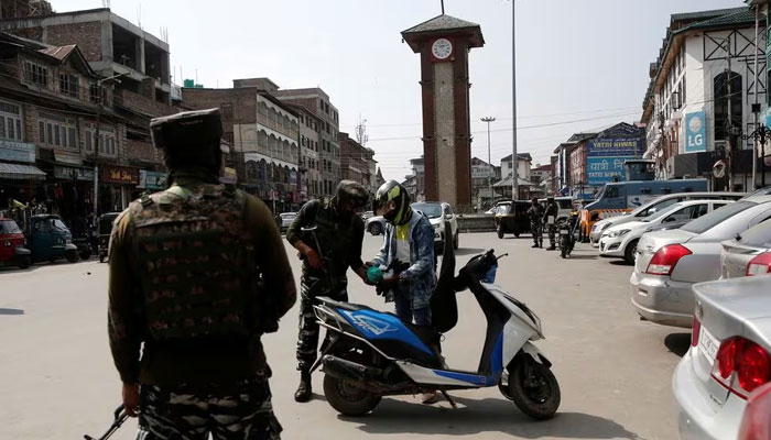 Indian Central Reserve Police Force (CRPF) personnel check the bags of a scooterist as part of security checking in Srinagar, October 12, 2021. — Reuters