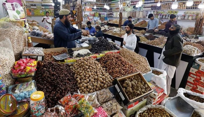 People buy dry fruits at a market in Karachi, Pakistan February 1, 2023. — Reuters