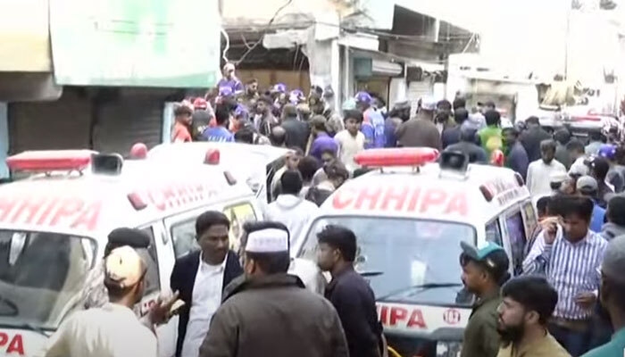 The picture shows a crowded street following a blast in Machar Colony, Karachi, on December 18, 2023. —Screengrab/Geo News