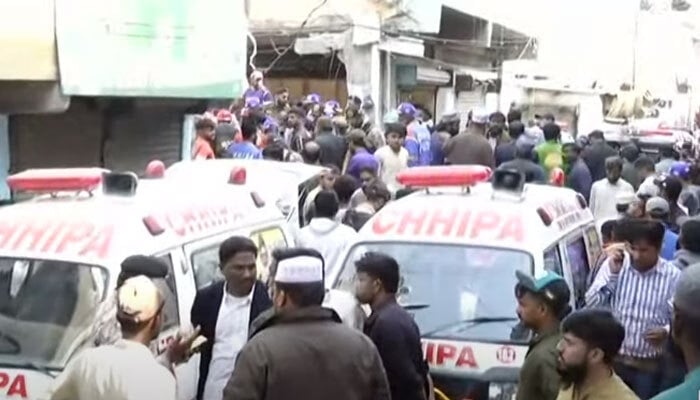 The picture shows a crowded street following a blast in Machar Colony, Karachi, on December 18, 2023. —Screengrab/Geo News