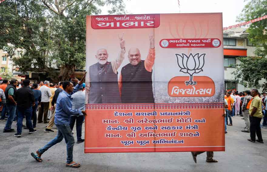 Supporters of Indias ruling Bharatiya Janata Party (BJP) carry a hoarding of Indian Prime Minister Narendra Modi and Union Minister of Home Affairs Amit Shah for celebrations after winning three out of four states in key regional polls outside the party headquarters in Ahmedabad, India, December 3, 2023. —Reuters