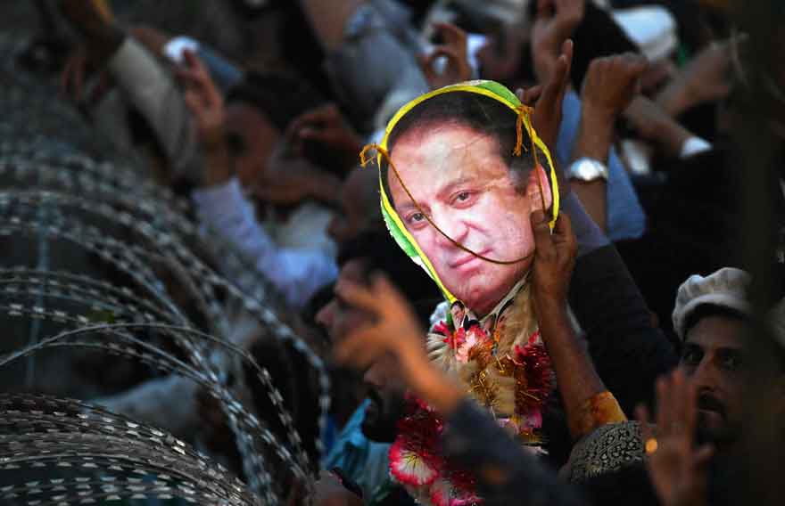 A supporter of former prime minister Nawaz Sharif holds a poster with his picture during an event held to welcome him in Lahore on October 21, 2023, upon his return to the country ending self-imposed exile. —AFP