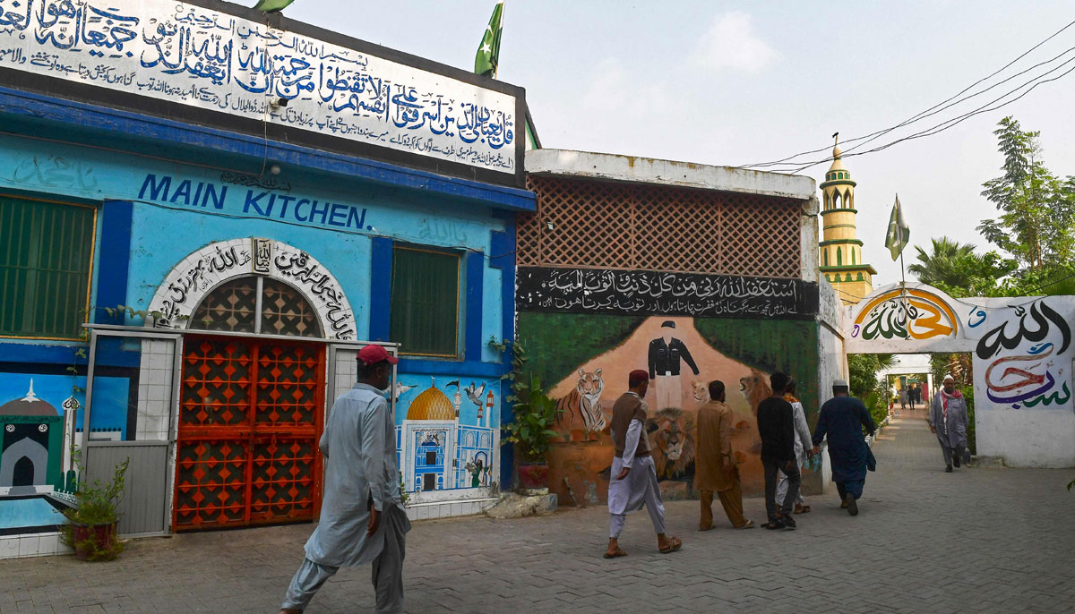 In this photograph taken on December 16, 2023, prisoners walk past the main kitchen laden with artworks by inmates, at the Central Jail in Karachi. — AFP