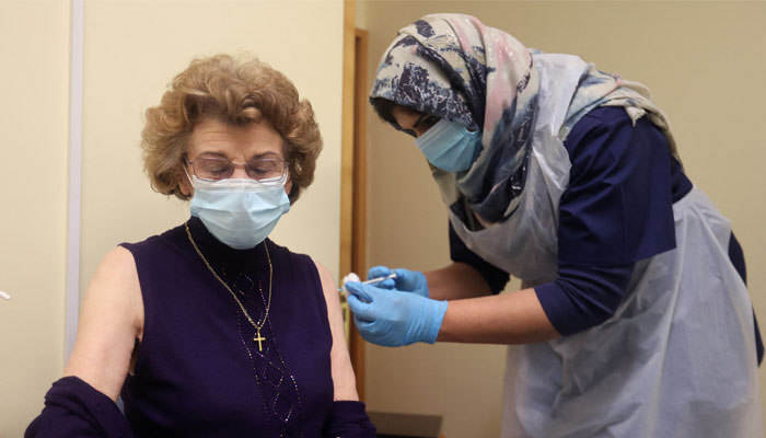 A patient receives the first of two injections with a dose of the Pfizer-BioNTech COVID-19 vaccine in a surgery in Wolverhampton, Britain December 14, 2020. — Reuters