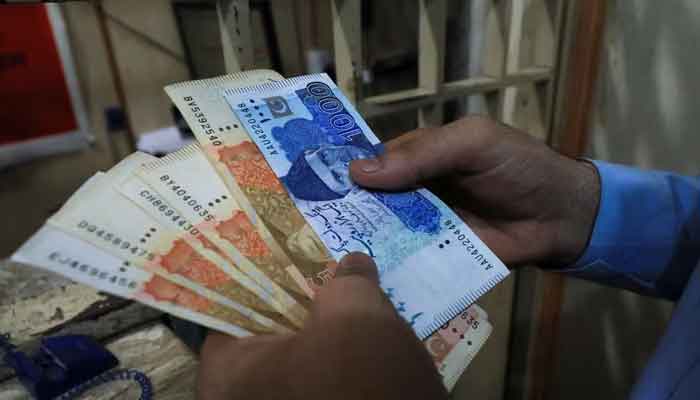 A man counts Pakistani rupee notes at a currency exchange shop in Peshawar on September 12, 2023. —Reuters