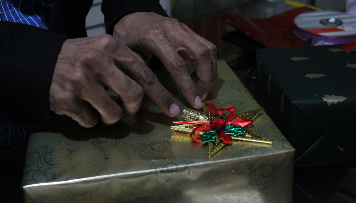 Jerome wraps a present for a customer adding some festive detailing on it. — Photo by author