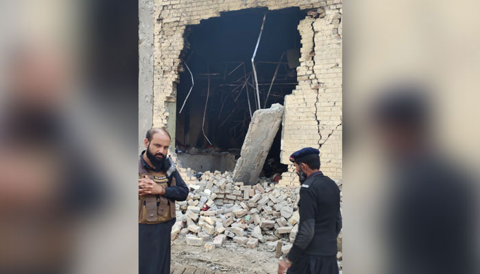 Police personnel stand at the site of an attack in DI Khan. — Geo News