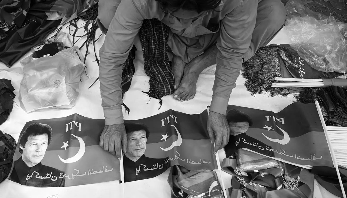 A vendor sells flags of Pakistan Tehreek-e-Insaf (PTI) party portraying Pakistans former prime minister Imran Khan, outside his residence in Islamabad on August 22, 2022. — AFP