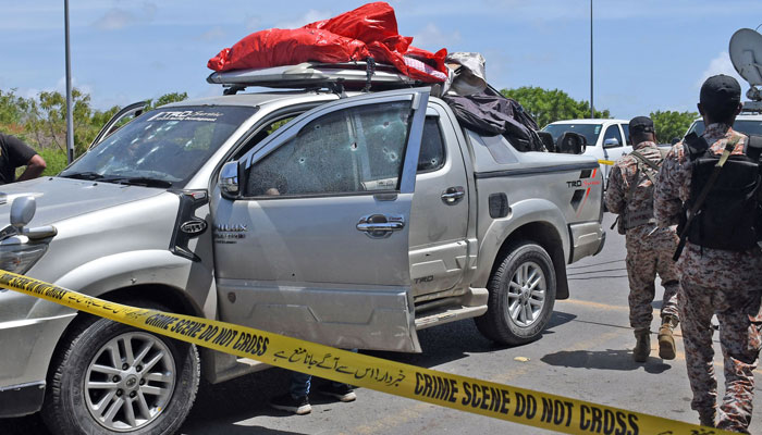 Pakistani security officials inspect the bullet-riddled vehicle after gunmen attacked the Defence Housing Authority area in Karachi on July 26, 2023. — Online