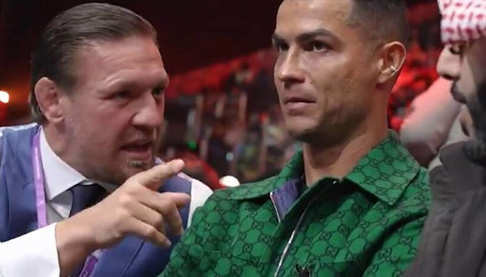 Conor McGregor tries to talk to Cristiano Ronaldo ringside in Riyadh.—TNT Sports