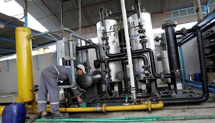 A worker drains water from a gas filter at the Egas processing plant in Gujar Khan, Pakistan March 10, 2017. — Reuters