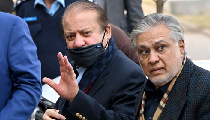 PML-N supremo Nawaz Sharif (L) waves as he arrives to appear before the High Court in Islamabad on December 7, 2023. — AFP