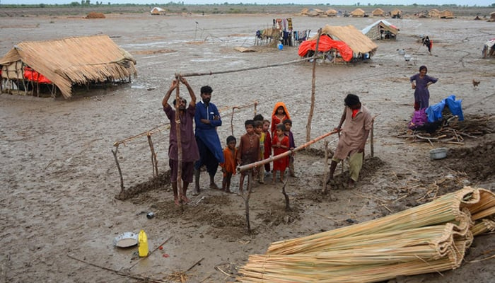 Cyclone-affected people build a hut in a coastal area in Sujawal. — AFP/File