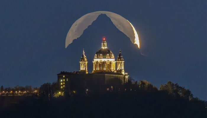 A shot of the Moon aligned perfectly with the Basilica of Supergas dome and the tip of Monviso, in the vicinity of Turin, Italy on December 15, 2023. — X/@JamesLucasIT via Valerio Minato