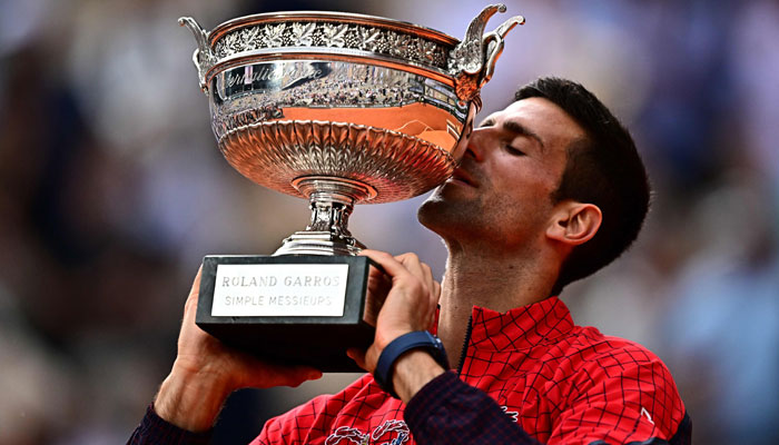 Serbias Novak Djokovic kisses his trophy as he celebrates his victory over Norways Casper Ruud during their men´s singles final match on day fifteen of the Roland-Garros Open tennis tournament at the Court Philippe-Chatrier in Paris on June 11, 2023. — AFP