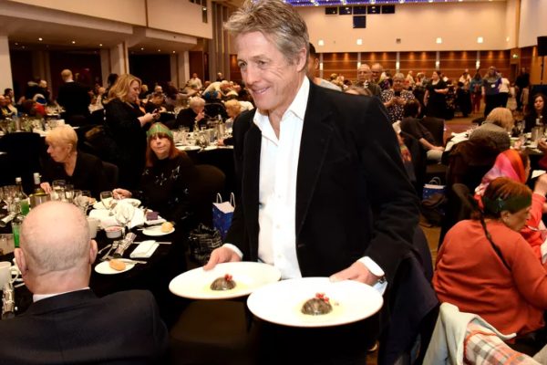 Hugh Grant serves lunch to the elderly at Christmas