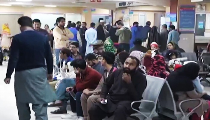 Patients sitting in the waiting area outside an outpatient department (OPD) of a Lahore hospital in this undated image in a screengrab taken from a video. — Geo News