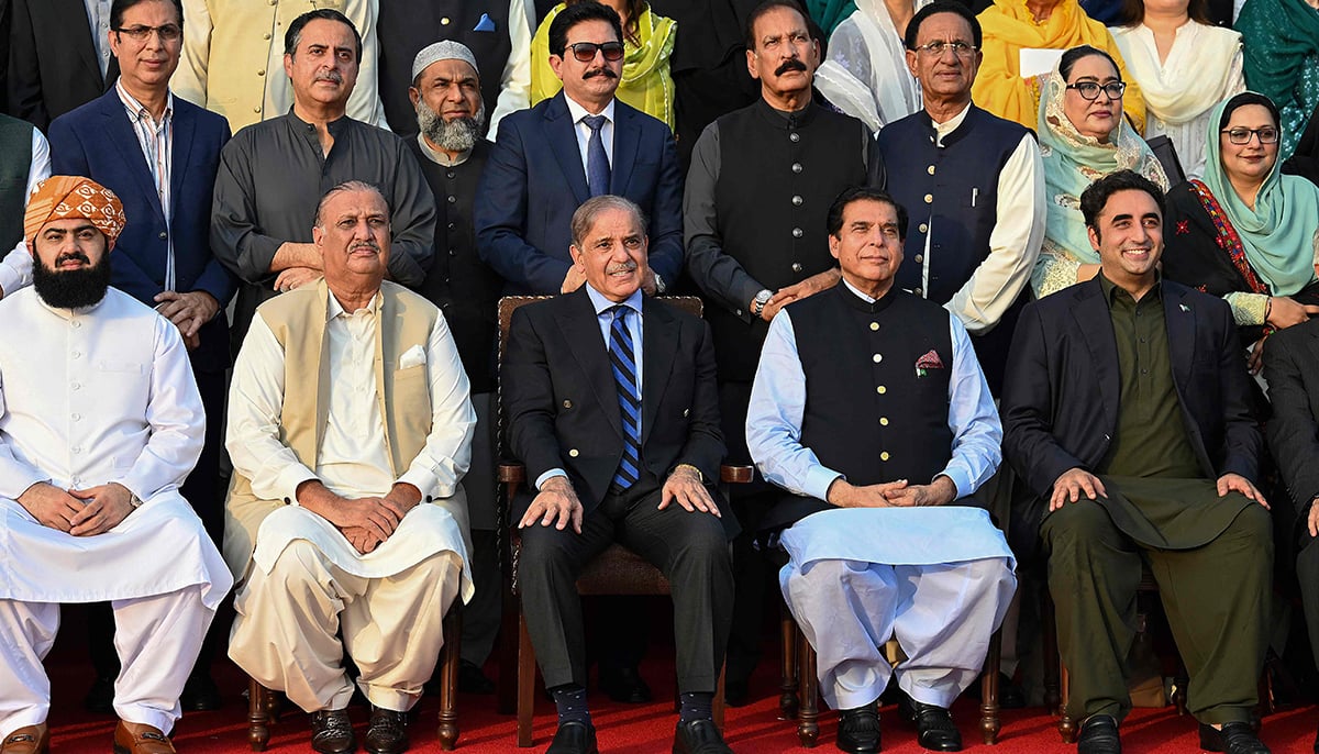 Former prime minister Shehbaz Sharif (3L in front row) poses for a photograph with parliamentarians after last session of National Assembly outside the parliament house building in Islamabad on August 9, 2023. — AFP