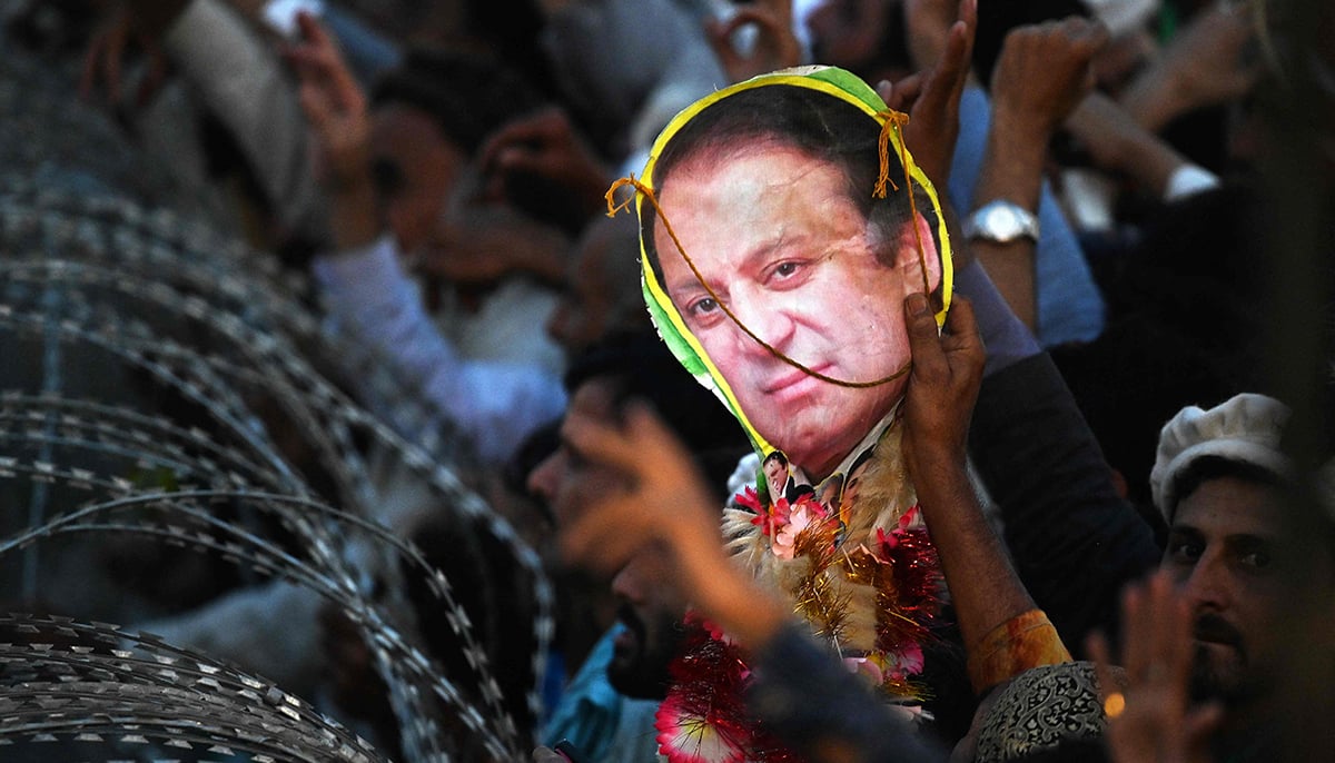 A supporter of former prime minister Nawaz Sharif holds a poster with his picture during an event held to welcome him in Lahore, on October 21, 2023. — AFP