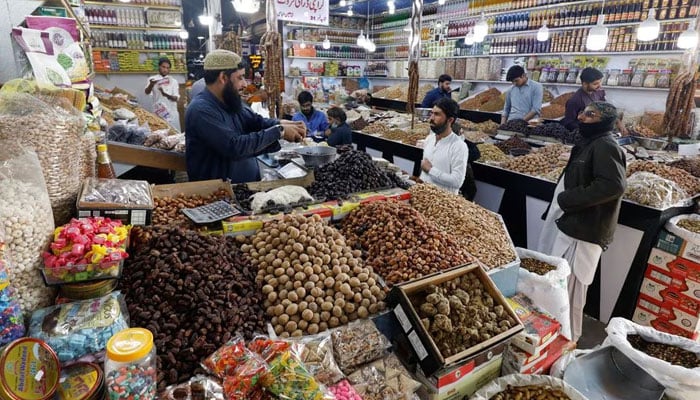 People buy dry fruits at a market in Karachi, Pakistan February 1, 2023. — Reuters