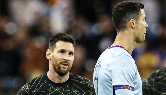 Caption 1: Messi looks at Ronaldo during the match —AFP