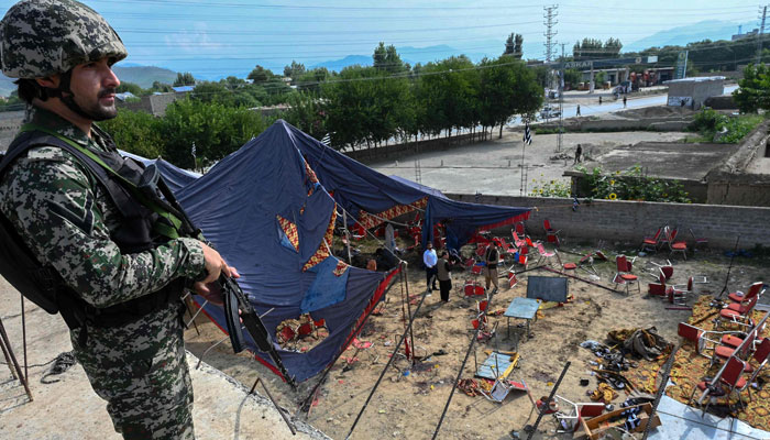 A security personnel stands guard next to the site of a bomb blast in Bajaur district of Khyber-Pakhtunkhwa province on July 31, 2023. — AFP