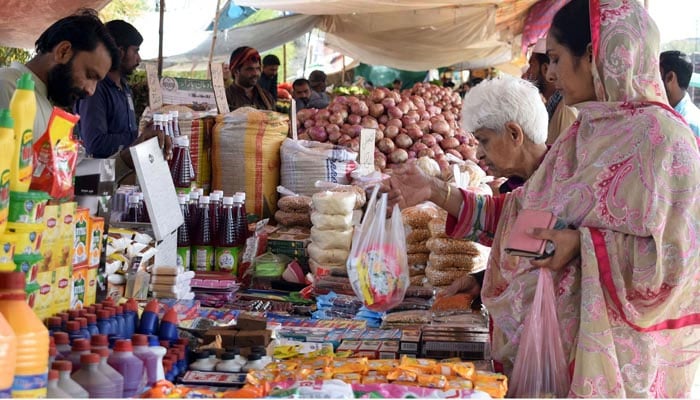 People are buying groceries from makeshift stalls at the weekly Sunday Market in Lahore on April 2, 2023. — Online