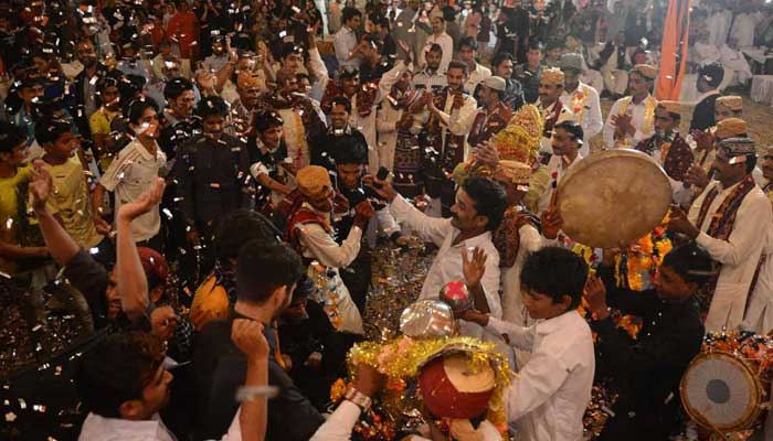 Grooms celebrate at a mass marriage ceremony in Karachi, March, 2013. — AFP