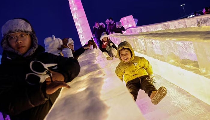 A child rides down an ice slide at the Harbin International Ice and Snow Festival, in Harbin, Heilongjiang province, China January 4, 2024. —Reuters