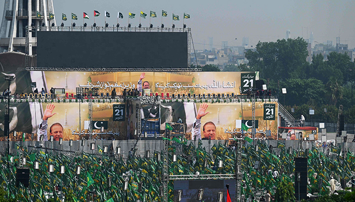 Supporters of Nawaz Sharif wait for his arrival for a welcoming rally at a park in Lahore on October 21, 2023. — AFP