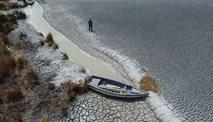 Manuel Flores walks on a dry area that shows the drop in the level of Lake Titicaca, Latin Americas largest freshwater basin, as it is edging towards record low levels, on Cojata Island, Bolivia October 26, 2023. —Reuters