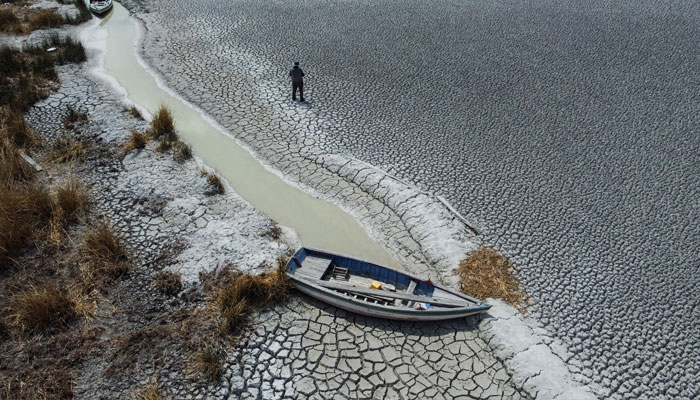 Manuel Flores walks on a dry area that shows the drop in the level of Lake Titicaca, Latin Americas largest freshwater basin, as it is edging towards record low levels, on Cojata Island, Bolivia October 26, 2023. —Reuters