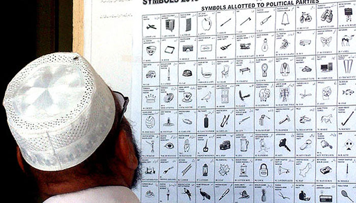 A man looking at election symbols allotted to political parties at a district court. — INP/File