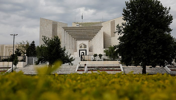 A man uses his mobile phone as he walks past the Supreme Court of Pakistan building in Islamabad, Pakistan May 13, 2023. — Reuters