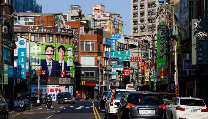 People ride past a campaign ad for Lai Ching-te, Taiwans vice president and the ruling Democratic Progressive Partys (DPP) presidential candidate and Justin Wu, local parliament member candidate for the ruling Democratic Progressive Partys (DPP) ahead of the election in Taipei, Taiwan January 12, 2024. —Reuters