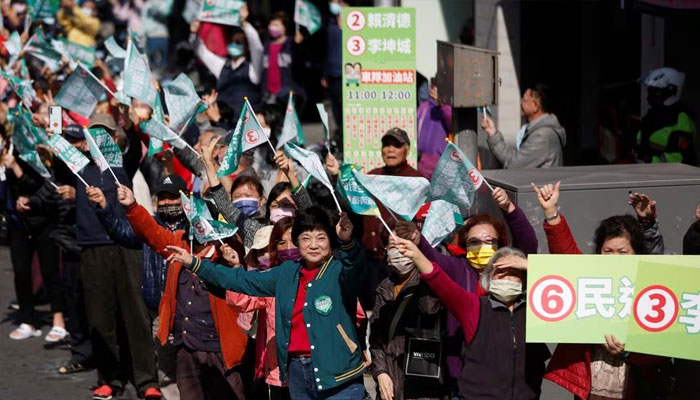 Supporters wave flags as Lai Ching-te, Taiwans vice president and the ruling Democratic Progressive Partys (DPP) presidential candidate, rides past in the back of a vehicle during a campaign event ahead of the elections in New Taipei City, Taiwan January 12, 2024. —Reuters