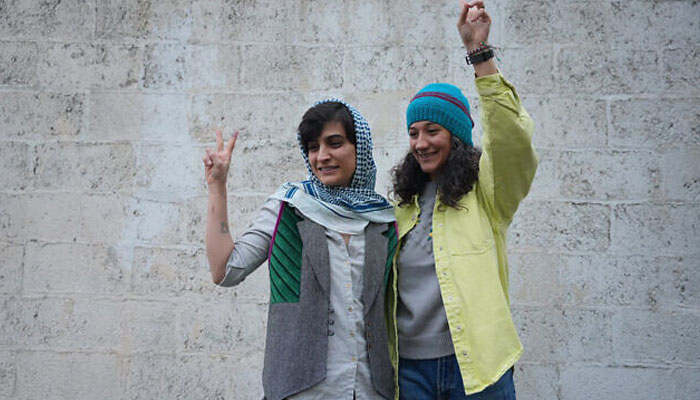 This picture taken and released by the Sharq News Online on January 14, 2024, shows Iranian journalists Niloufar Hamedi (R) and Elaheh Mohammadi flashing the sign of victory after they were released from Evin prison on bail in Tehran. —AFP