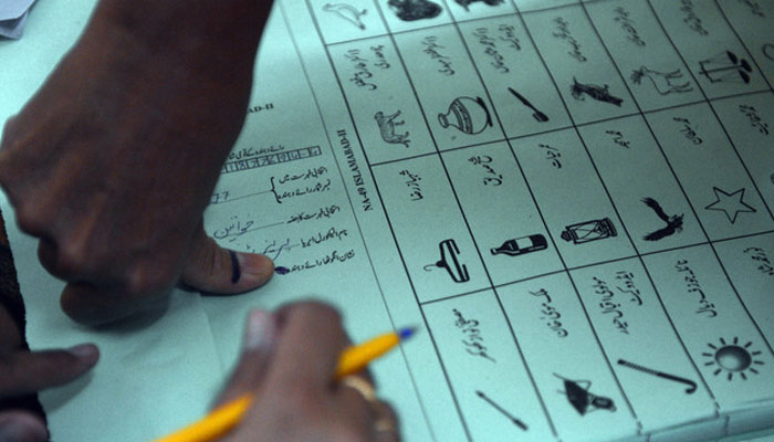 A Pakistani female voter presses her inked thumb onto a ballot paper before she casts her vote at a polling station in Islamabad on May 11, 2013. — ADP/File