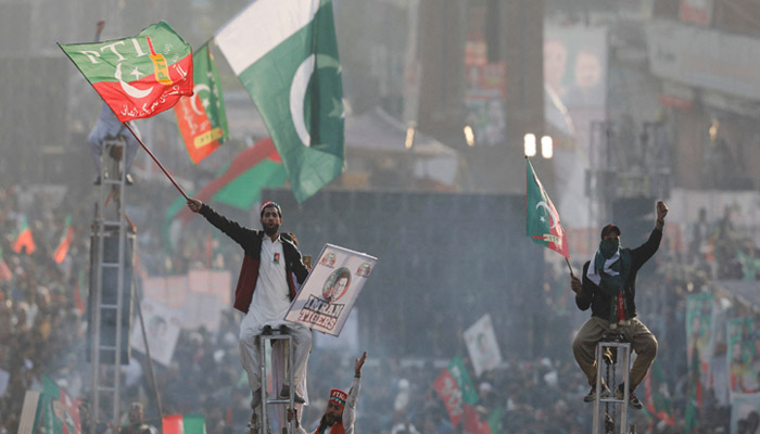 PTI supporters sit on scaffoldings in Rawalpindi, on November 26, 2022. — Reuters