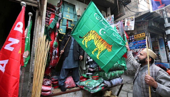 A man is buying PML-N flag from shop at Qissa-Khwani Bazaar in Peshawar ahead of the General Elections. — INP