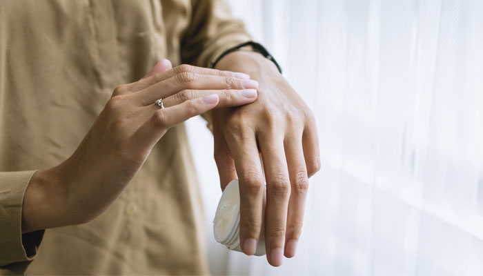 An individual applies moisturiser to their hands. — Unsplash