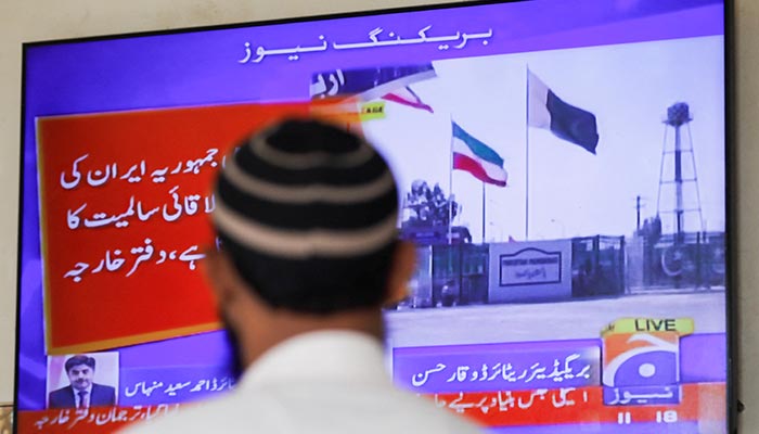 A man looks at a television screen after the in Karachi, on January 18, 2024. — Reuters