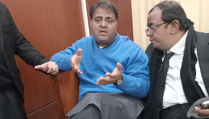 Former federal minister Fawad Chaudhry speaking to his lawyer at a court in this undated image. — X/@TabraizAurah
