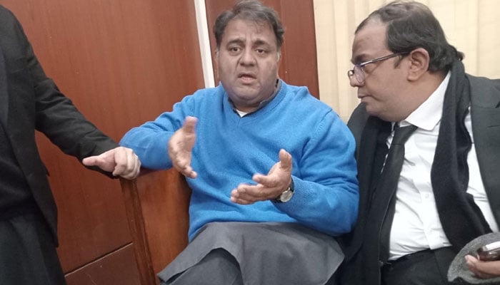 Former federal minister Fawad Chaudhry speaking to his lawyer at a court in this undated image. — X/TabraizAurah