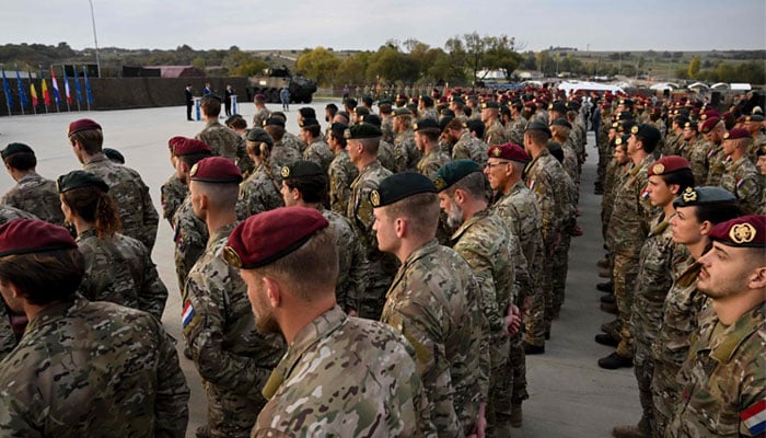 Dutch soldiers listen to Dutch Prime Minister Mark Rutte (L), Romanian President Klaus Iohannis (C) and Romanian Prime Minister Nicolae Ciuca (R) speak during a visit to the Cincu military base in Cincu village on October 12, 2022. —AFP